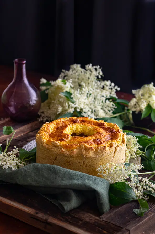 Torta di ricotta e fiori di sambuco o soffione abruzzese. Intera, su un tavolo di legno.